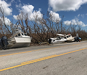 A highway with several boats beside it, blown onto land by Hurricane Irma.